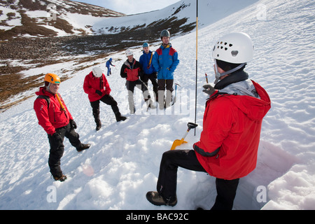 A member of the Scottish Avalanche Information Service demonstrates how to assess avalanche risk on Cairngorm Stock Photo