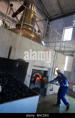 Distillery workers shovel coal into the fires below the Yoichi whisky stills, Nikka whiksy, Yoichi, japan Stock Photo