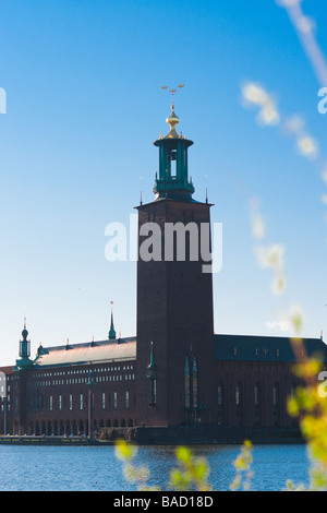 The city hall of Stockholm with a blurred twig with green leaves suggestive of spring and summer in the foreground. Stock Photo