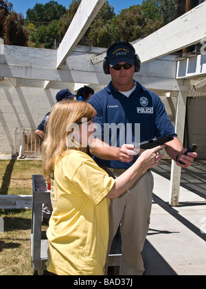 Police officer instructs female citizen police academy member in using the Glock 9mm automatic pistol at the RBPD firing range Stock Photo