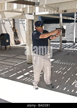 Range officer demonstrates proper firing position holding Glock 9mm automatic pistol Stock Photo