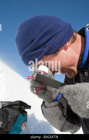 A member of the Scottish Avalanche Information Service looks at snow crystals to help assess avalanche risk Stock Photo