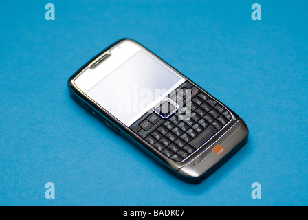 Nokia E71 mobile phone with QWERTY keyboard against a blue background Stock Photo