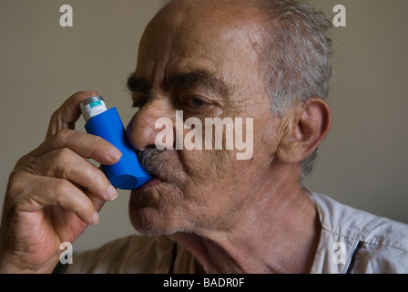 Senior man using an inhaler treatment for Asthma Stock Photo