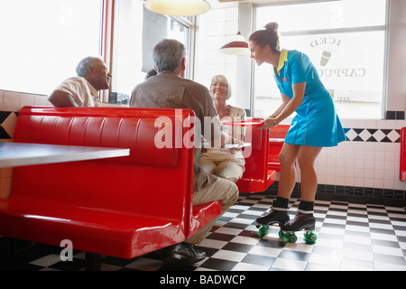 Waitress Serving Customers in Retro Diner Stock Photo