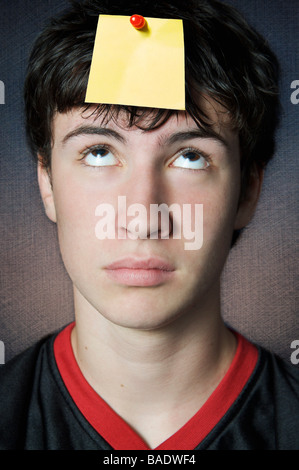 Teenager Looking at Blank Note Pinned to his Head Stock Photo