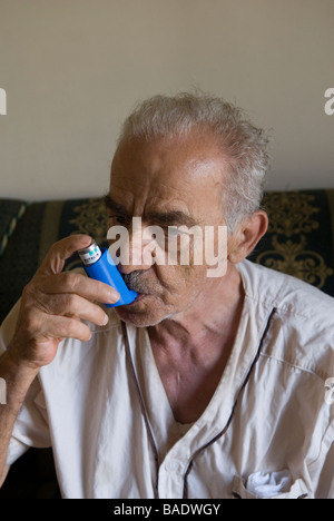 Senior man using an inhaler treatment for Asthma Stock Photo