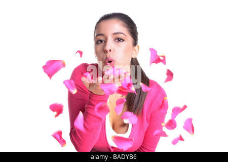 An attractive woman blowing pink rose petals from her hand isolated on white background Motion blur on the petals Stock Photo