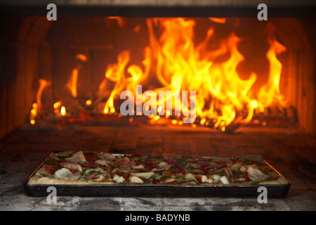 Pizza Cooking in Outdoor Pizza Oven Stock Photo