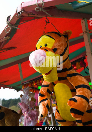 Disney 'Tigger'. A stuffed cuddly toy tiger, offered as a prize, hanging from a stall at a fairground. UK. Stock Photo