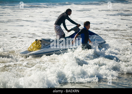 MEXICO San Jose del Cabo Man riding jet ski in shallow water near beach and man running in waves Stock Photo