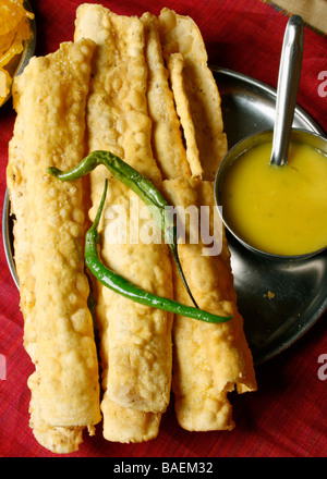 Fafda is a popular Gujarati snack made of gram flour black pepper & eaten with green chillies Stock Photo