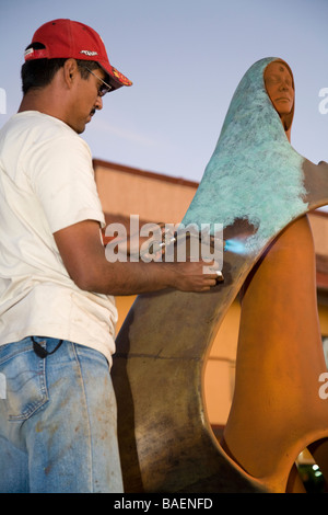 MEXICO La Paz Artist Rocio Sanchez use blow torch to apply finish to bronze sculpture La Reina del Mar the Queen of the Sea Stock Photo