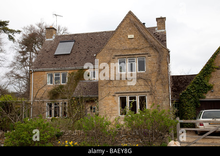 Solar thermal evacuated tubes to heat water on tile roof of large Cotswold house UK Stock Photo