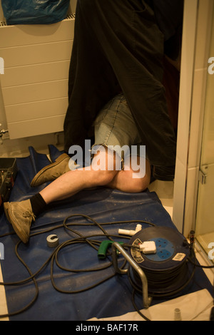 Heating engineers working in a  gas boiler cupboard Stock Photo