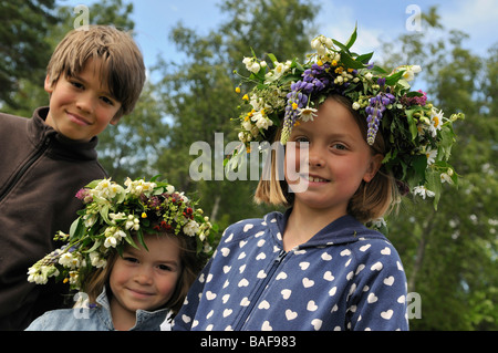 Smiling girls with floral wreath and boy at Midsummer celebration in Doessberget Sweden June 2008 Stock Photo