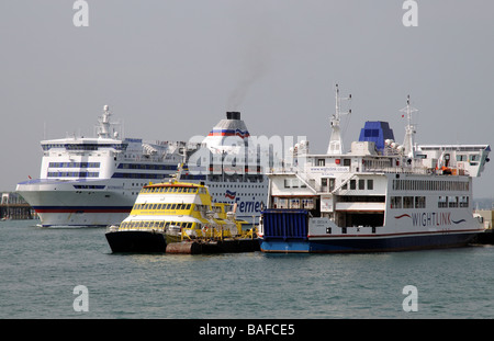 RORO ferries The Normandie of Brittany Ferries company passing moored Wightlink vessels Portsmouth Harbour England UK Stock Photo