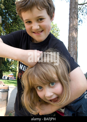 Young boy and girl brother and sister play fighting in head lock  FULLY MODEL RELEASED Stock Photo