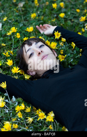 Portrait of a girl lying in flowers Stock Photo - Alamy