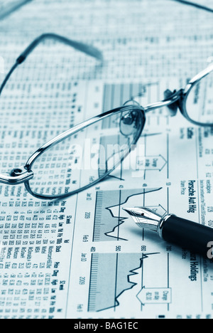 glasses and pen on financial newspaper Stock Photo