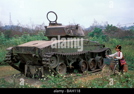 Vietnam, Dien Bien Province, relics of Dien Bien Phu Battle, woman from Black Thai ethnic group and tank of the French Army Stock Photo