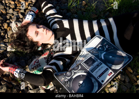 Woman lying down on rocks with hand bag Stock Photo
