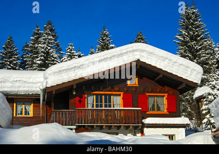 Snow covered blockhous in a forest region, La Givrine, Jura region, Switzerland Stock Photo