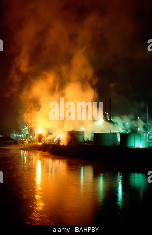 Steam emanating from a refinery in Warren Pennsylvania is reflected in the dusk sky and Allegheny River Stock Photo