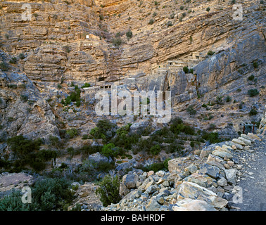 remote village with some houses built in the mountains Abgelegenes Dorf cave village Sayq Plateau Oman Stock Photo