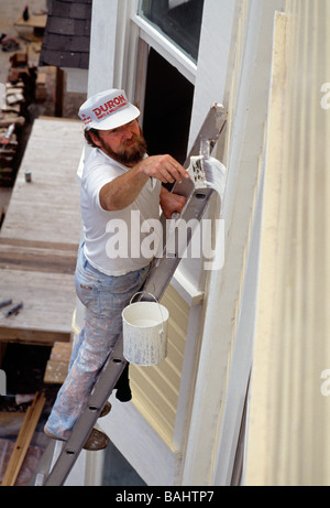 Worker on a ladder painting a historical house in Charleston South Carolina USA Stock Photo