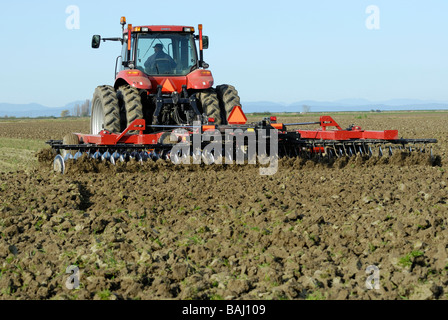 Farmer disk ripping a field, preparing it for planting. Stock Photo