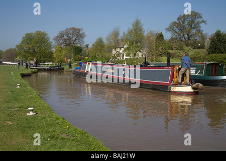 Beeston Cheshire England UK April Man steering his narrowboat towards Beeston Iron lock on the Shropshire Union Canal Stock Photo