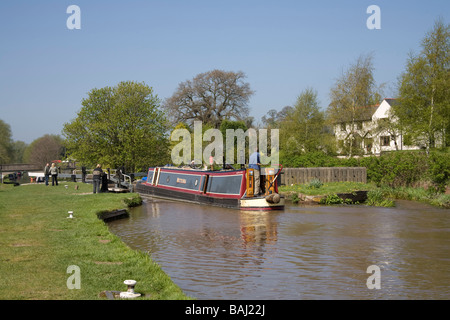 Beeston Cheshire England UK April Man steering his narrowboat into Beeston Iron lock on the Shropshire Union Canal Stock Photo