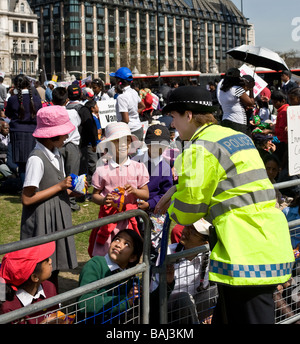 A friendly Metropolitan female Policewoman talking to Tamil schoolchildren at a protest in Westminster in in London. Stock Photo