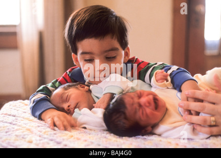 Hispanic boy twin brother sister baby babies sibling hug love cozy care cry concern proud pride protect Stock Photo