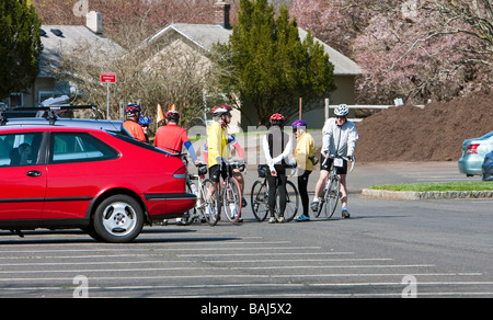 A group of senior bicycle rides meeting in the parking lot of a park to take a morning ride. Stock Photo