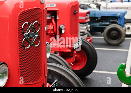 Row of vintage farm tractors in a carpark. Front tractor has "Perkins Diesel" badge on grille. Stock Photo