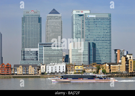 High rise offices & low rise riverside apartments Canary Wharf development area in East London Docklands River Thames  on the Isle of Dogs England UK Stock Photo