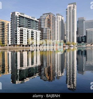 Reflection on water of urban flat apartment housing in real estate development in regeneration of Inner Millwall Dock Isle of Dogs East London UK Stock Photo