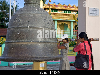 Women praying in front of the Sacred Bell. Botataung Paya. Yangon. Myanmar Stock Photo