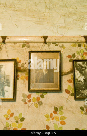 Framed photographs of a man in his youth on the wall of a house that hasn't been cleaned for more than twenty years Stock Photo