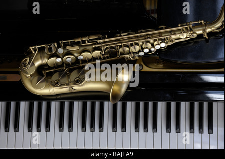 Alto saxophone lying on a grand piano Stock Photo