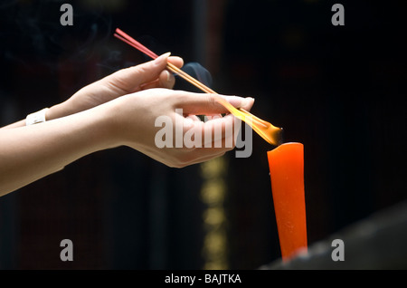 View of two female hands lighting up incense, Wenshu Temple, Chengdu, Sichuan, China 2008 Stock Photo