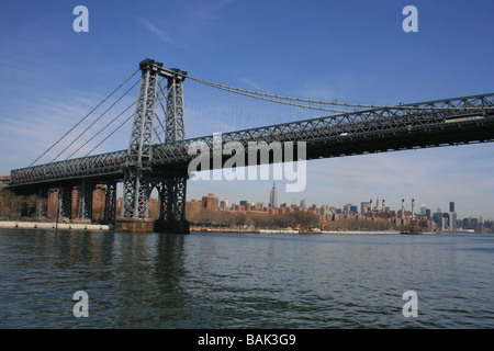 Williamsburg Bridge along the East River (Empire State Building in the background). Stock Photo