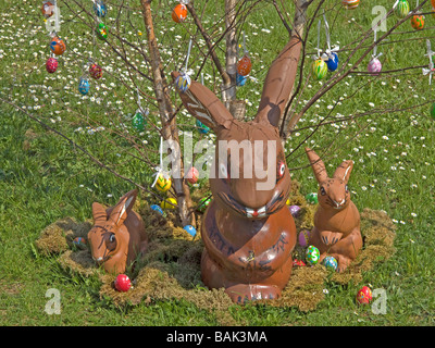 three easter bunnies with coloured easter eggs on a meadow in Weißenohe Bavaria Upper Franconia Germany Stock Photo