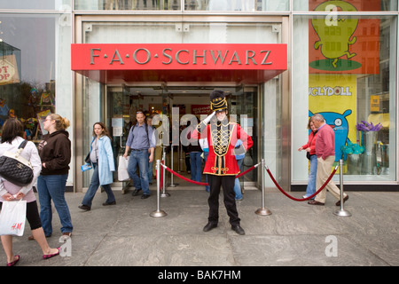 Doorman salutes customers at FAO Schwartz toy store Fifth Avenue New York City Stock Photo