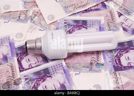 Energy saving lightbulb on a pile of British Money Stock Photo