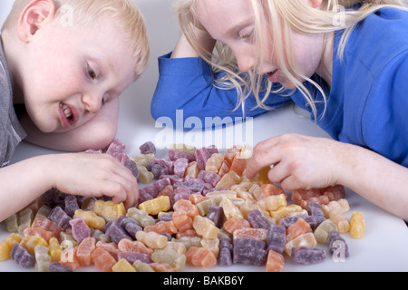 Blonde haired children counting jelly baby sweets. Stock Photo