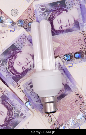 Energy saving lightbulb on a pile of British Money Stock Photo