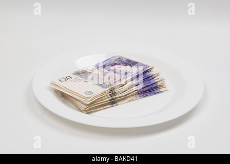 Stack of British money on a white plate Stock Photo